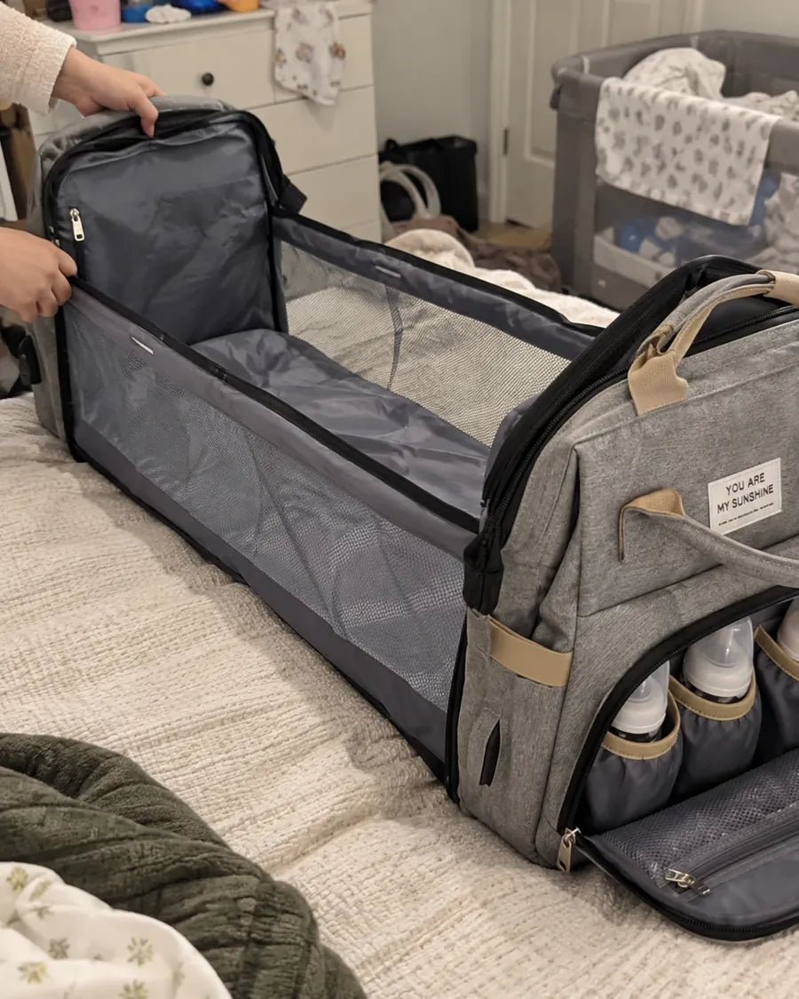 Buyer's photo: opening the backpack's fold-out changing station on a bed