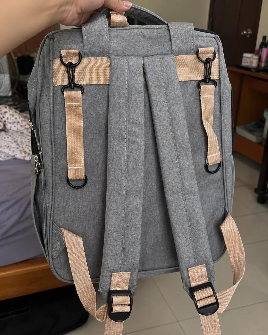 Buyer's photo: the back of the grey backpack with its straps and clips